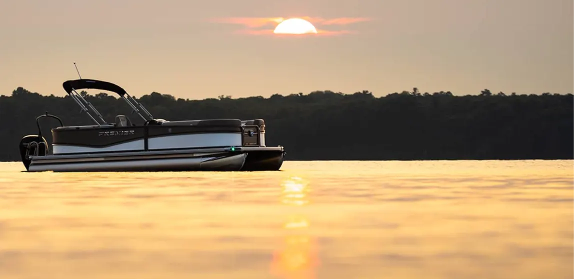 Premier pontoon silhouetted on a golden lake at sunset