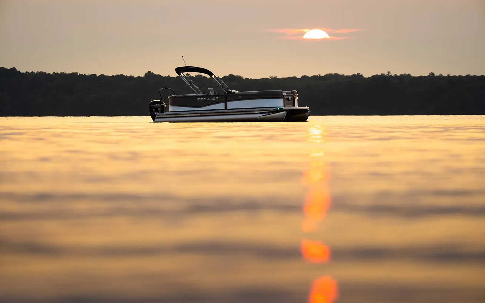 Pontoon anchored on a calm lake at sunset
